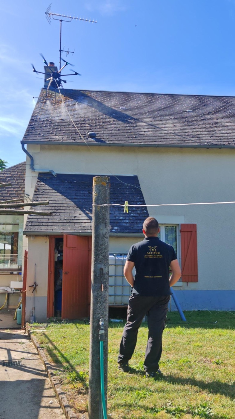 Traitement d’une toiture en ardoise par drone, l’opérateur Altipur pilote depuis la pelouse, aucun accès au toit.