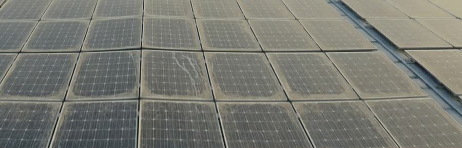 Le même champ de panneaux solaires couvert d’un voile de poussière et de traces.